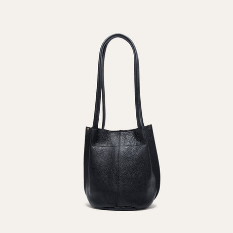 Top-down view into the empty black leather bucket bag, showing the magnetic snap closure