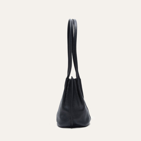 Black leather bucket bag, side profile view showing the rounded gusset
