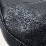 Macro close-up of the black leather bucket bag's embossed Will Leather Goods logo