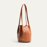Caramel leather bucket bag, three-quarter angle view showing the shape and stitching