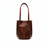 Will Leather Goods cognac leather bucket bag, front view with long shoulder straps, on a white background