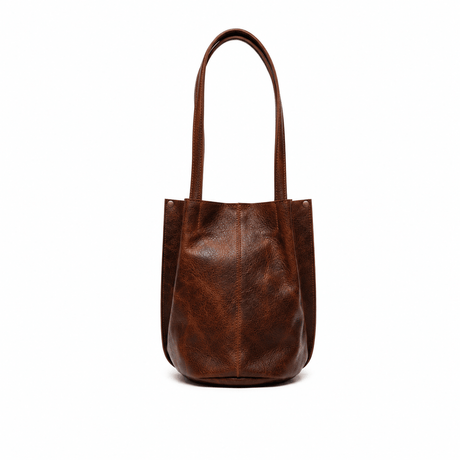 Will Leather Goods cognac leather bucket bag, front view with long shoulder straps, on a white background
