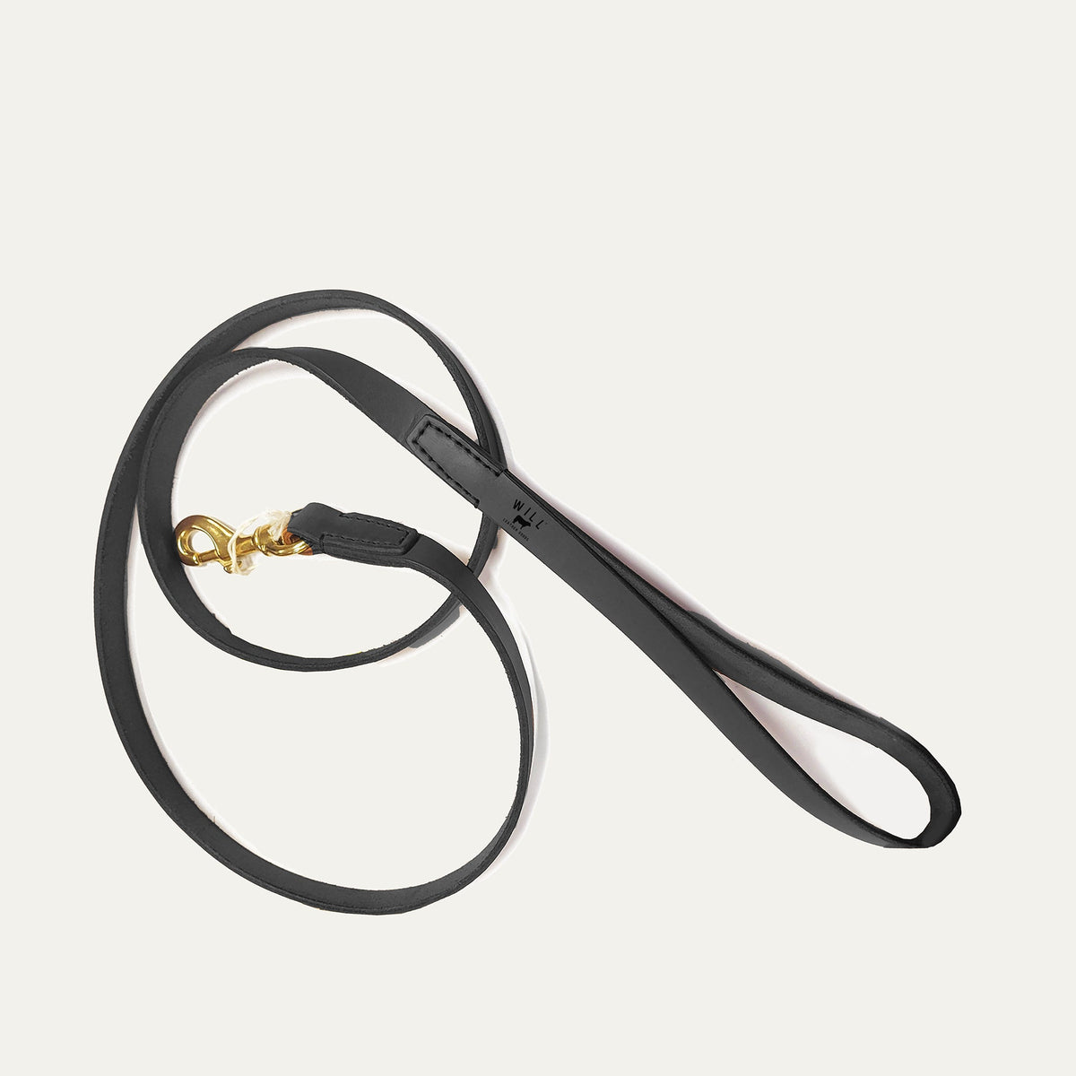 Will Leather Goods black leather dog leash coiled on a white background, showing the brass clasp