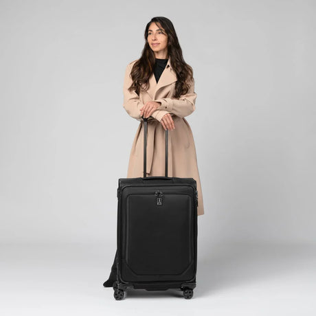 Traveler standing with the Travelpro Crew Classic medium check-in spinner