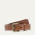 Will Leather Goods Bridal Belt in cognac leather, coiled to show the multiple sizing holes and antique brass roller buckle, on a white background.
