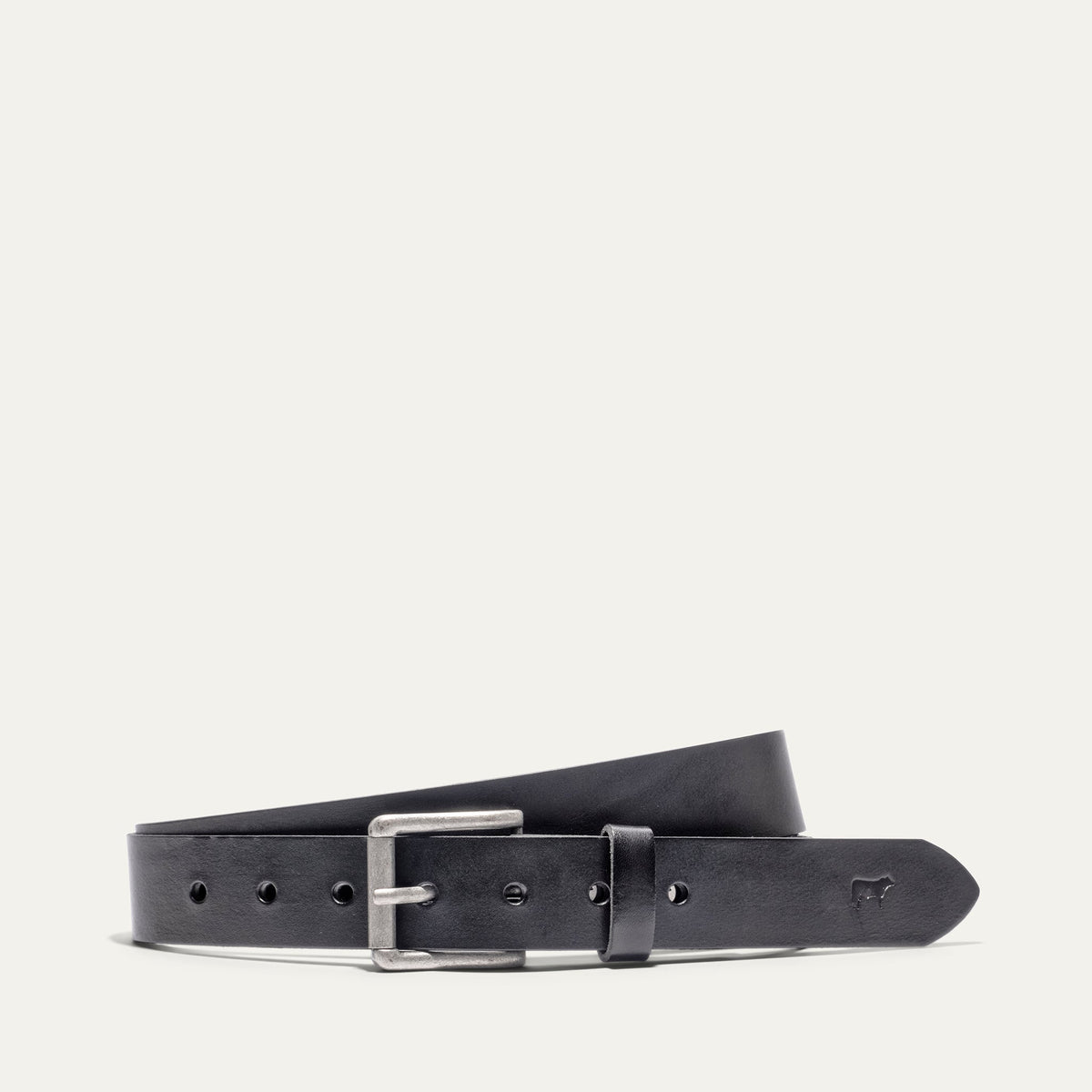 Will Leather Goods Bridal Belt in black leather, laid flat with the antique silver roller buckle and embossed cow-head logo near the tip, on a white background.