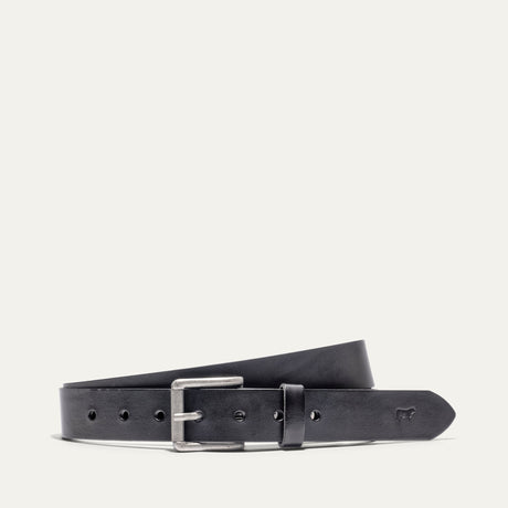 Will Leather Goods Bridal Belt in black leather, laid flat with the antique silver roller buckle and embossed cow-head logo near the tip, on a white background.