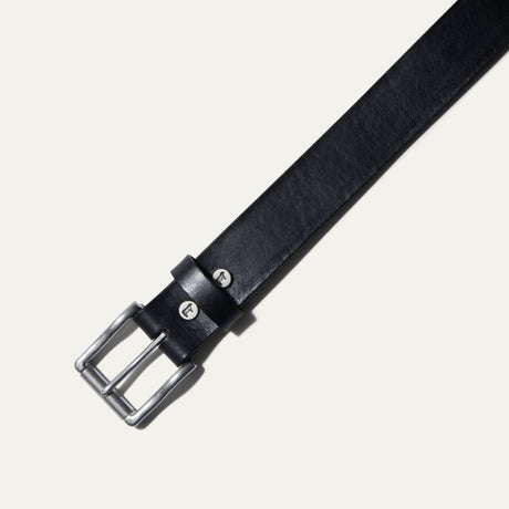 Close-up of the black leather belt's brushed nickel buckle and keeper loop with cattle snaps