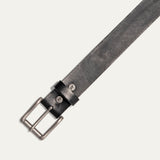 Close-up diagonal view of the black leather Bridal Belt's antique silver roller buckle, sizing holes, and embossed cow-head rivets on the keeper loop.