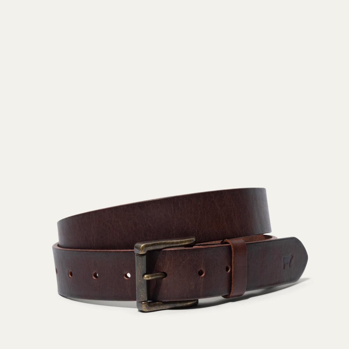 Will Leather Goods dark brown leather belt coiled, showing the antique brass roller buckle