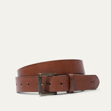 Will Leather Goods cognac leather belt coiled, showing the antique brass roller buckle
