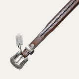 Close-up of the cognac brown tapered lace belt showing the woven lace-wrapped strap texture and silver keeper with a Will Leather Goods hang tag.