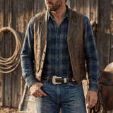 Man wearing the cognac brown tapered lace belt with jeans and a leather vest, close-up on the silver western buckle.