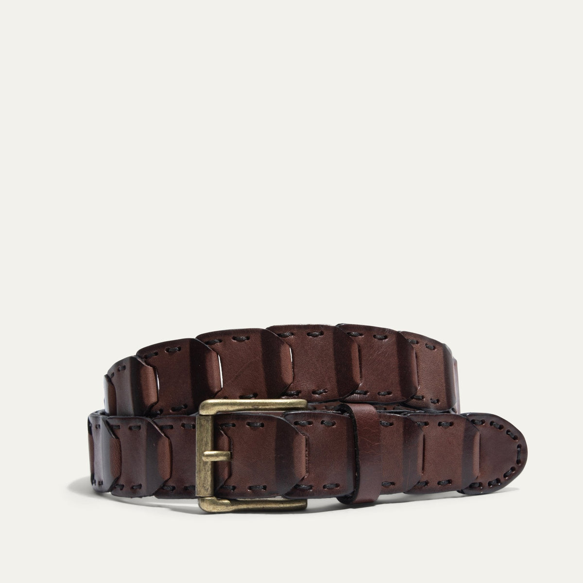 Will Leather Goods Hand Laced Link Belt in brown leather, coiled to show the hand-laced rectangular link panels and antique brass roller buckle, on a white background.