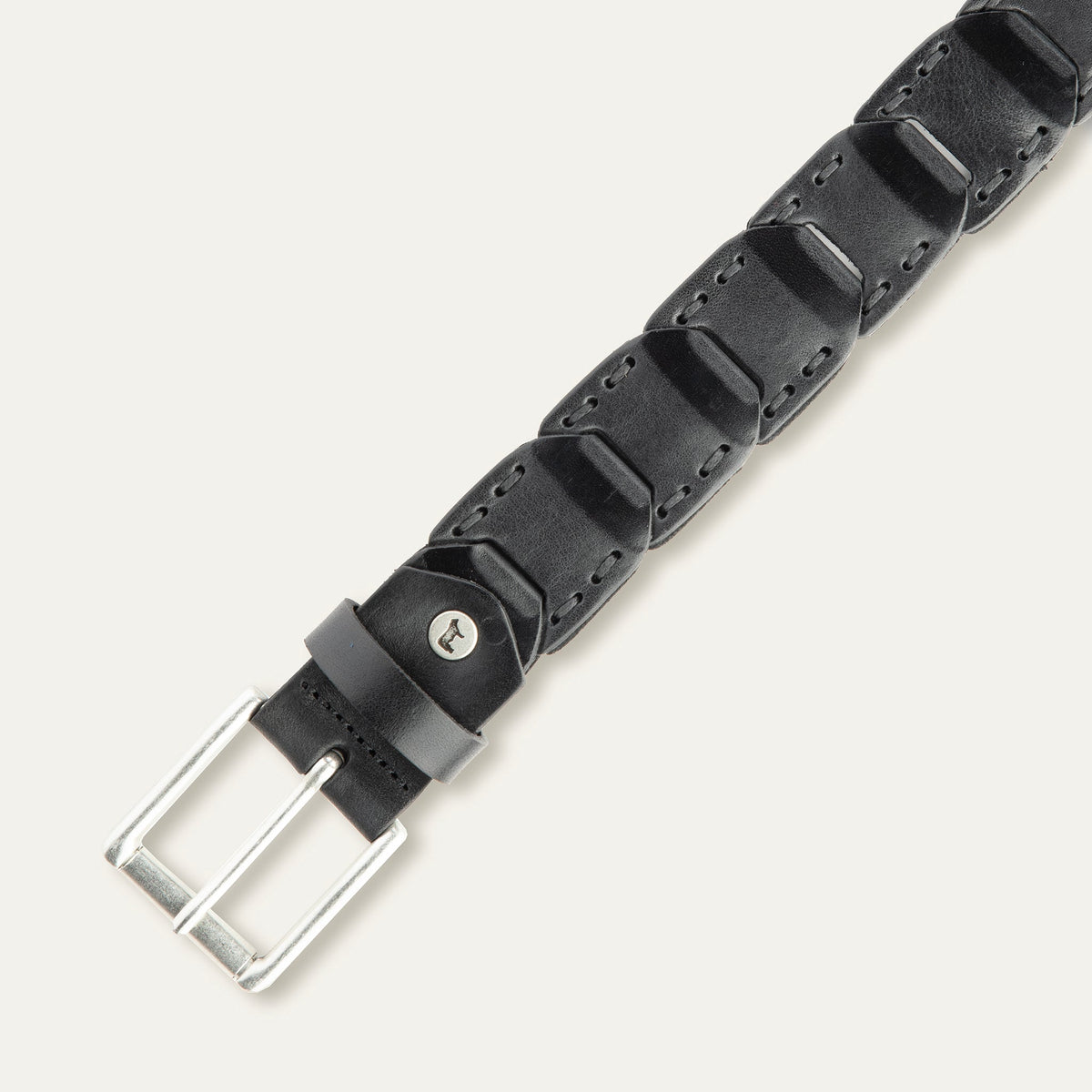 Close-up overhead view of the black leather Hand Laced Link Belt showing the hand-laced stitching between rectangular link panels and the antique silver roller buckle.