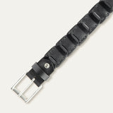 Close-up overhead view of the black leather Hand Laced Link Belt showing the hand-laced stitching between rectangular link panels and the antique silver roller buckle.