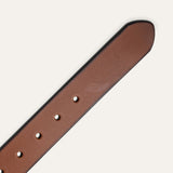 Close-up of the Black Edge Jean Belt strap in cognac leather, showing the black burnished edge trim and row of adjustment holes near the rounded tip.