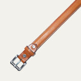 Close-up of the Rainbow Stitched Belt buckle in tan leather, showing the brushed nickel roller buckle and embossed WILL Leather Goods dog logo rivet.