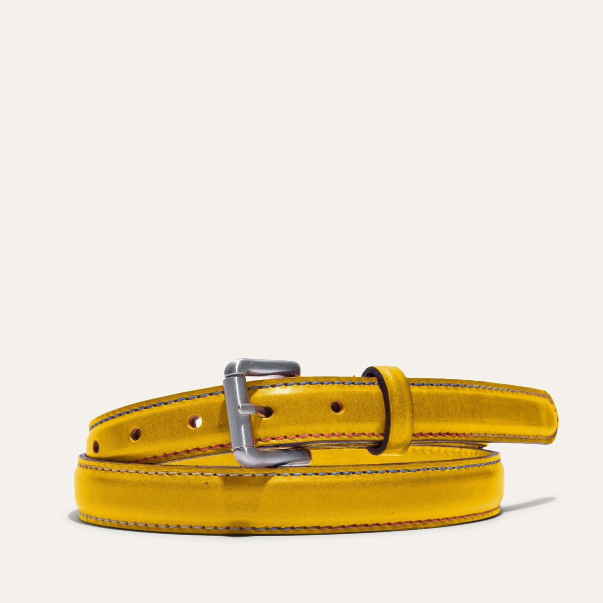 Close-up of the Rainbow Stitched Belt buckle in yellow leather, showing the brushed nickel roller buckle and multicolor edge stitching.