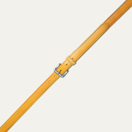 Close-up of the Rainbow Stitched Belt strap tip in yellow leather, showing the multicolor blue and red edge stitching and row of adjustment holes.