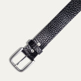 Close-up of the Shrunken American Bison Belt buckle in black pebbled bison leather, showing the brushed nickel buckle and embossed WILL Leather Goods dog logo rivets.