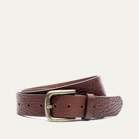 Shrunken American Bison Belt by WILL Leather Goods in brown pebbled bison leather with an antique brass buckle, coiled front product view on a white background.