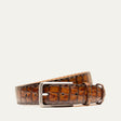 Will Leather Goods Croco Belt in cognac crocodile-embossed leather with a brushed silver buckle, coiled product shot on a white background.