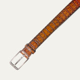 Close-up of the cognac Croco Belt's silver buckle and crocodile-embossed leather strap with belt loop keeper, product shot on a white background.