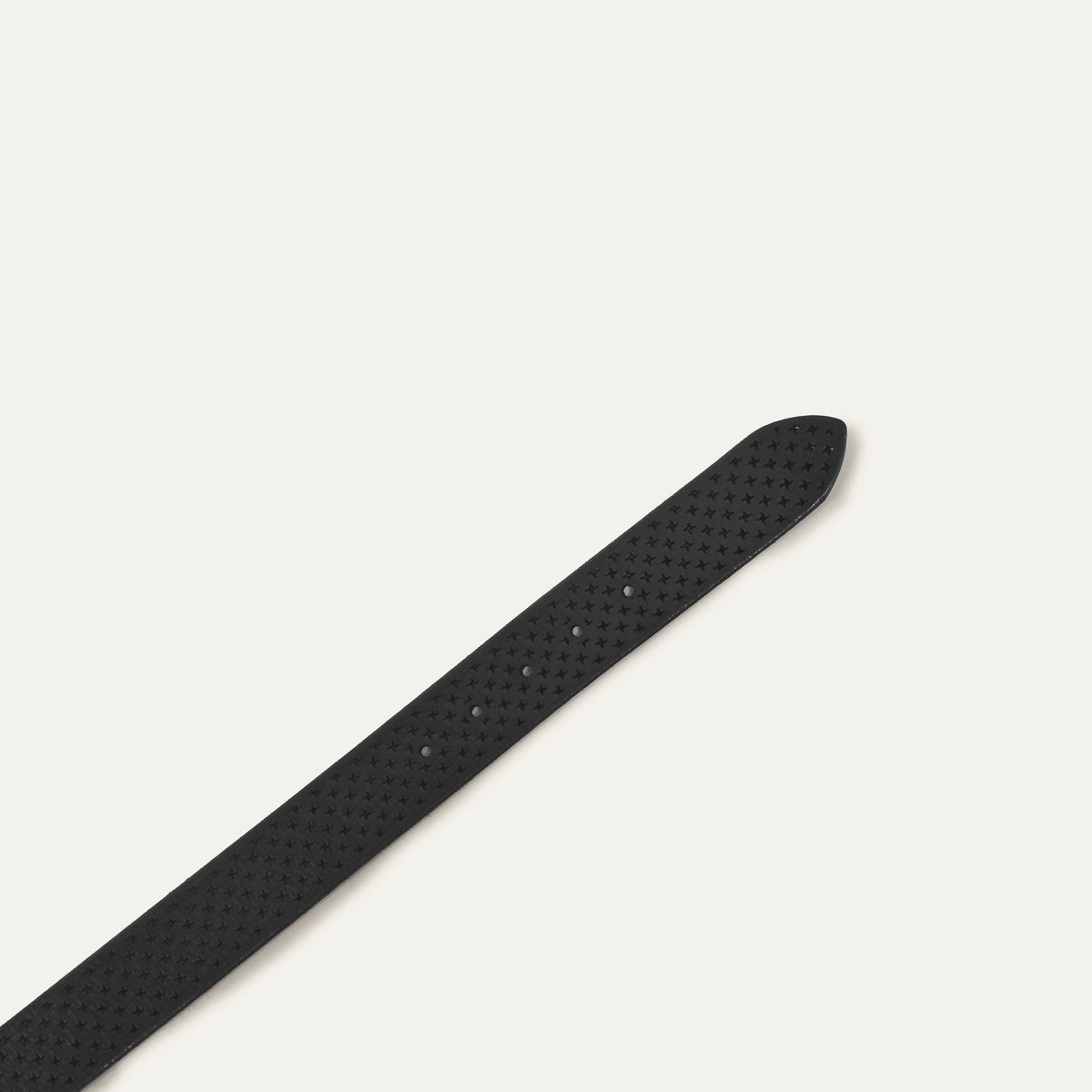 Close-up of the black leather belt's pointed tip showing the star perforations