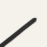 Close-up of the black leather belt's pointed tip showing the star perforations