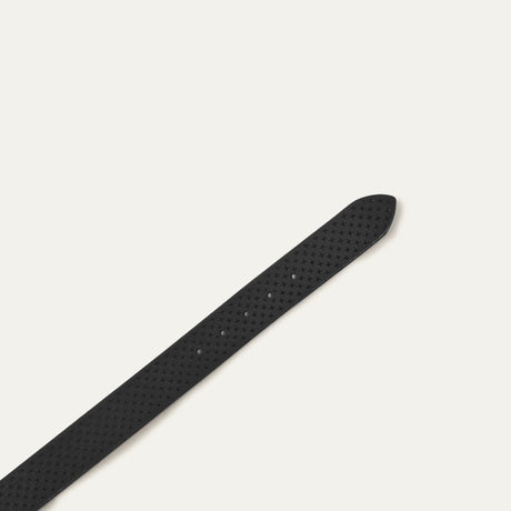 Close-up of the black leather belt's pointed tip showing the star perforations