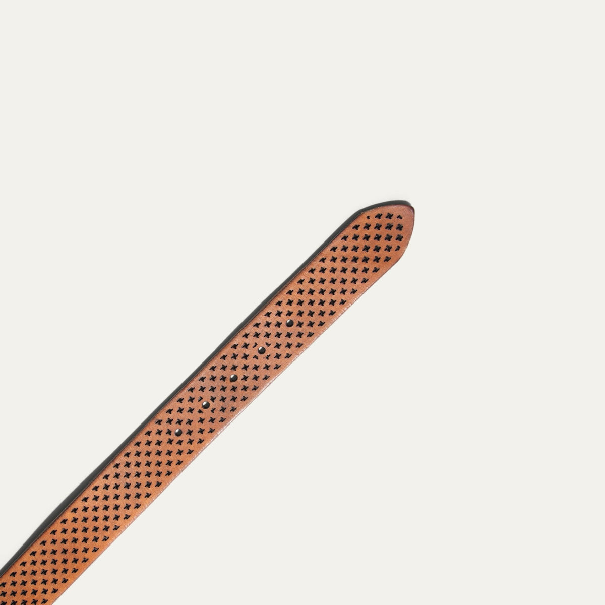 Close-up of the tan leather belt's pointed tip showing the star perforations and snap closures
