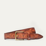 Tan leather belt coiled to show the brass buckle and fine embossed line texture running the length of the strap