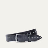 Will Leather Goods Single Studded Belt in black leather, coiled flat showing the row of silver stud rivets along the edge and the brushed silver buckle, on a white background.