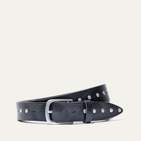 Will Leather Goods Single Studded Belt in black leather, coiled flat showing the row of silver stud rivets along the edge and the brushed silver buckle, on a white background.