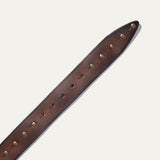 Close-up of the Will Leather Goods Single Studded Belt strap tip in brown leather, showing the row of antique brass stud rivets and adjustment holes.