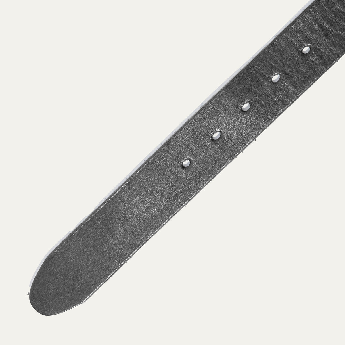 Close-up of the black leather buckle belt strap showing grain texture and the row of metal-grommeted buckle holes.