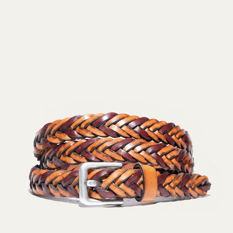Will Leather Goods Two-Tone Five Strand Braided Belt in brown and tan leather, coiled to show the herringbone braid pattern and brushed silver buckle, on a white background.