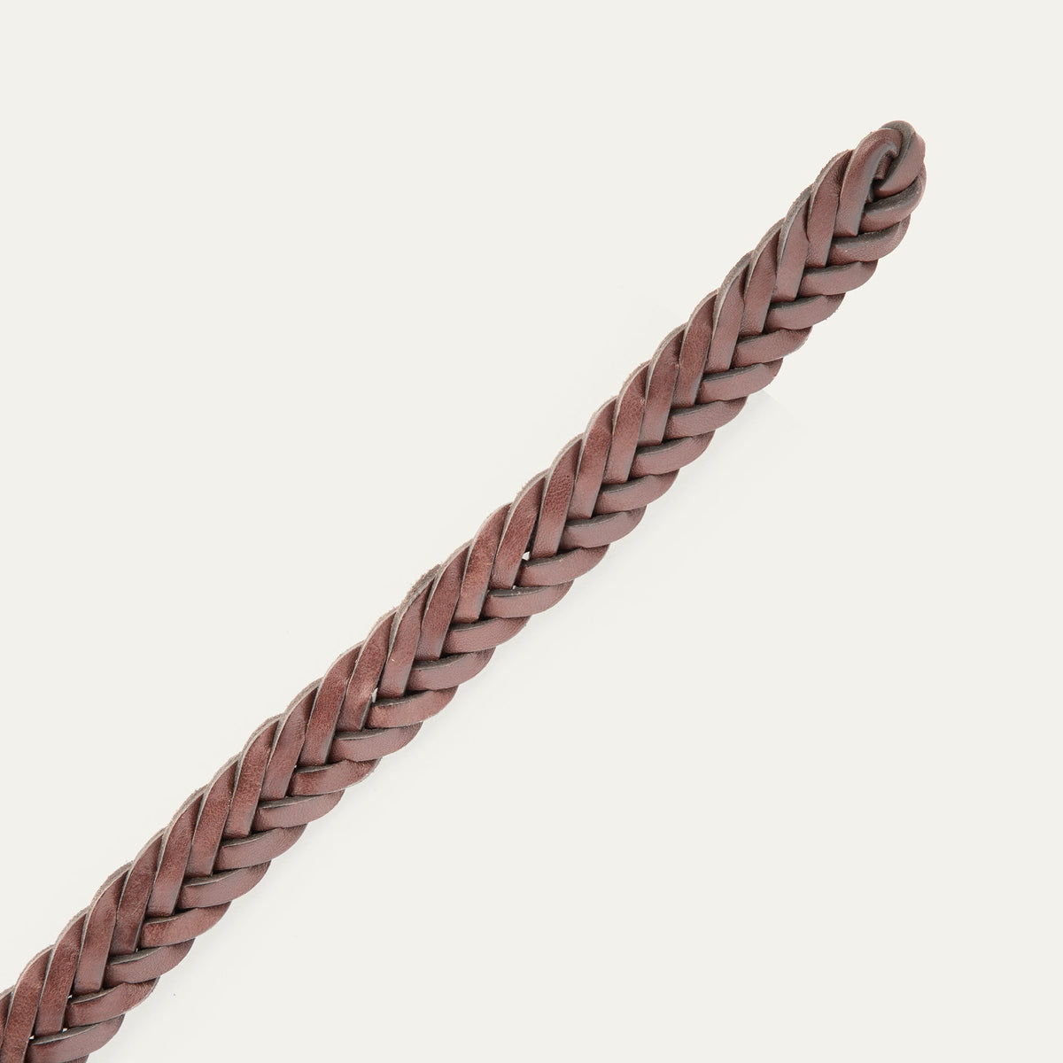 Close-up of the brown Five Strand Braided Belt's rounded, buckle-free tip end, showing the five-strand leather braid.