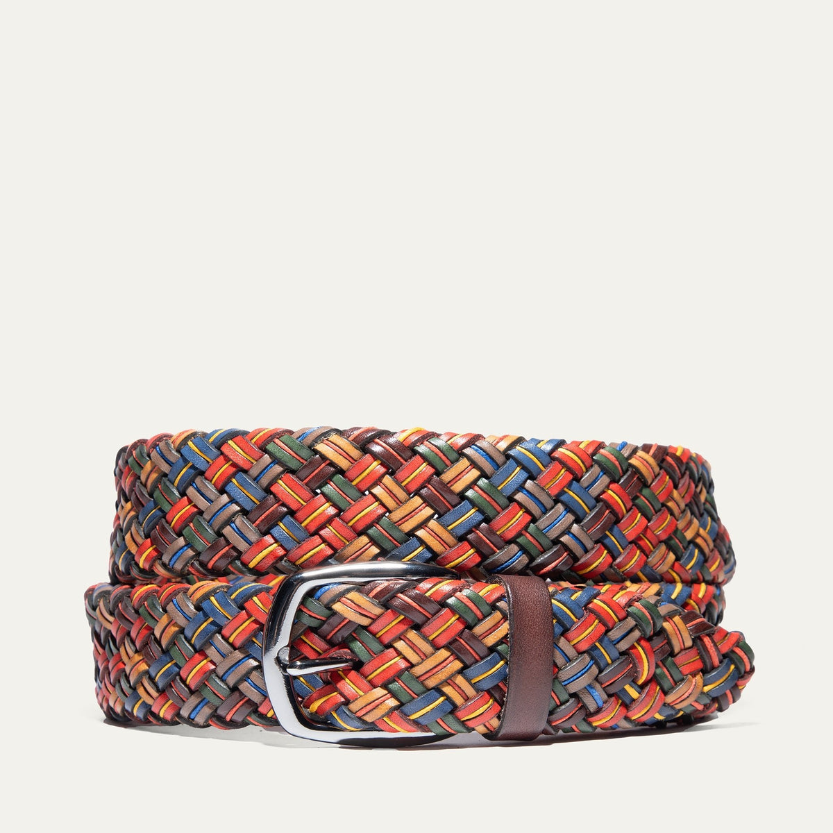 Will Leather Goods multi-color tubular braided belt, coiled product shot on a white background, showing the tight herringbone weave in red, blue, green, tan, and brown leather strands with a polished silver buckle.