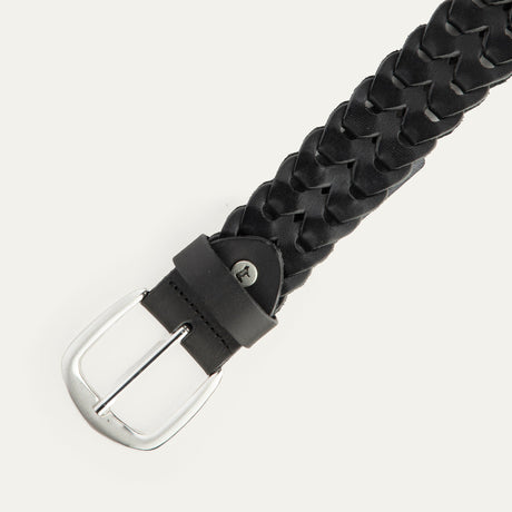 Close-up angled view of the black woven leather W Link belt showing the brushed silver buckle and braided texture