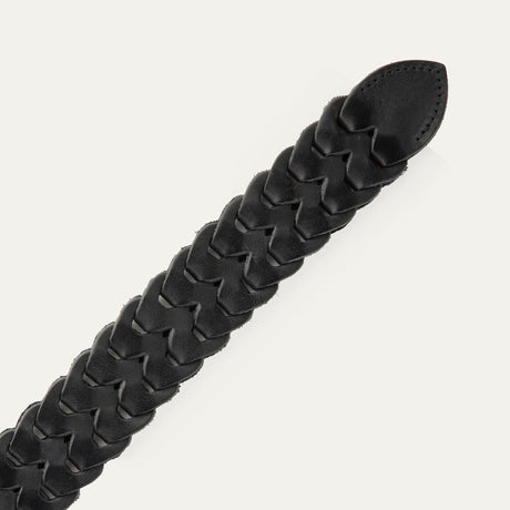 Close-up of the black woven leather W Link belt's pointed tail end and interlocking braid pattern