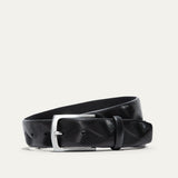 Will Leather Goods Wave Embossed Belt in black, coiled flat showing the wave-textured embossed leather and brushed silver buckle, on a white background.
