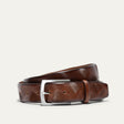 Will Leather Goods Wave Embossed Belt in cognac brown, coiled flat showing the wave-textured embossed leather and brushed silver buckle, on a white background.