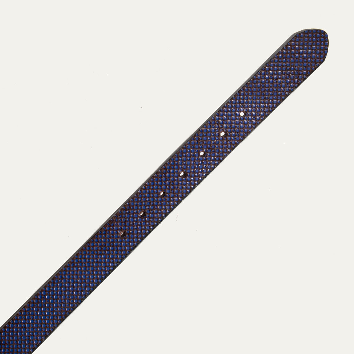 Close-up of the brown and blue diamond-embossed leather belt strap tip end with adjustment holes.