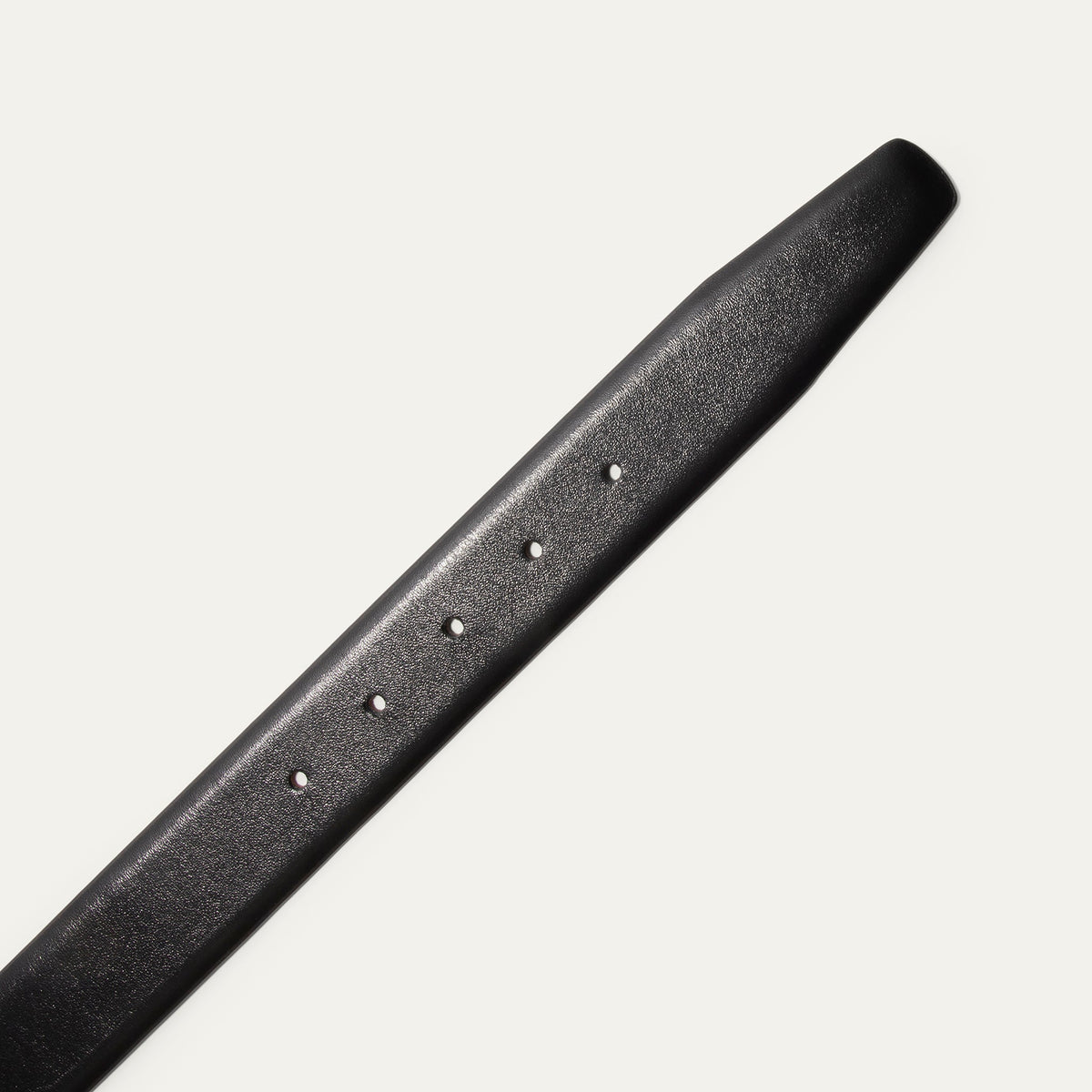 Close-up of the Will Leather Goods Glazed Calfskin Belt strap in black, showing the row of adjustment holes and the smooth glazed leather finish.
