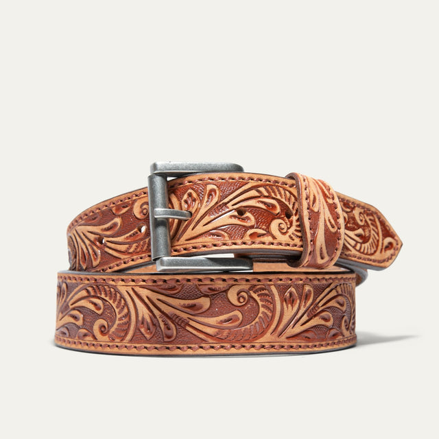 Hand-Tooled Morning Glory Jean Belt by WILL Leather Goods in natural tan leather with a hand-tooled floral pattern and antique nickel buckle, coiled front product view on a white background.