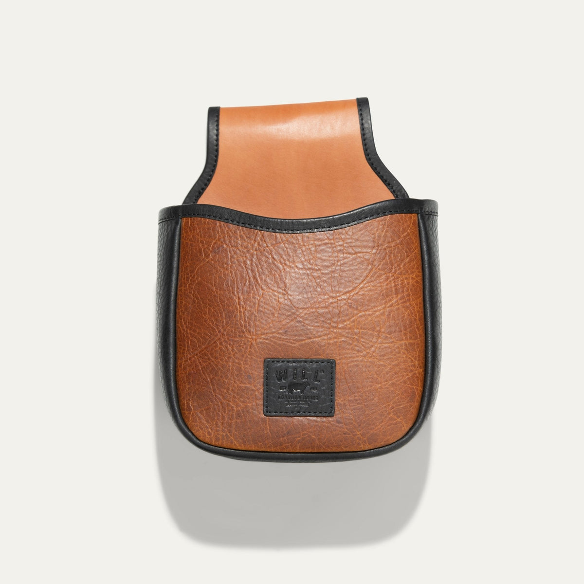 Will Leather Goods Ammo Belt Bag in cognac pebbled leather with black trim, back product view showing the embossed WILL leather patch and belt loop tab, on a white background.
