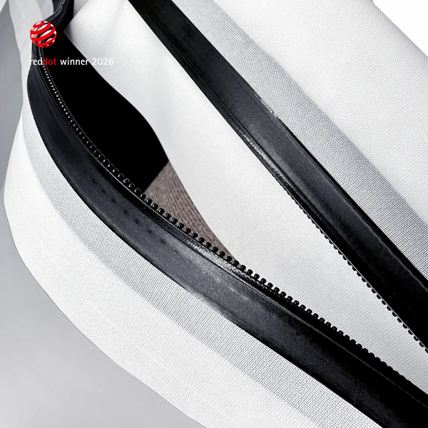 Extreme close-up of the black airtight zipper running along a white TILLIV Compak pack