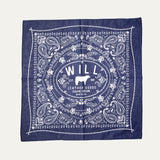 Will's Bandana in navy blue paisley print, laid flat showing the center WILL Leather Goods cattle-brand logo, on a white background.